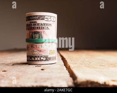 Different Dollar banknotes on a rustic wooden table, Income or savings amount concept Stock Photo