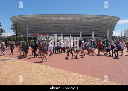 crowds of people, fans, supporters arrive for the rugby sevens final day match at Cape Town stadium, Green Point, South Africa some wear fancy dress Stock Photo
