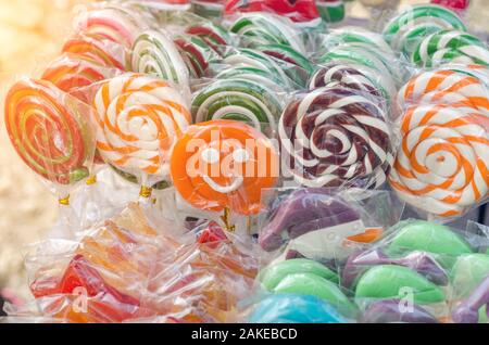Great choice of colorful caramel on stick candy for sale in shop window. Stock Photo