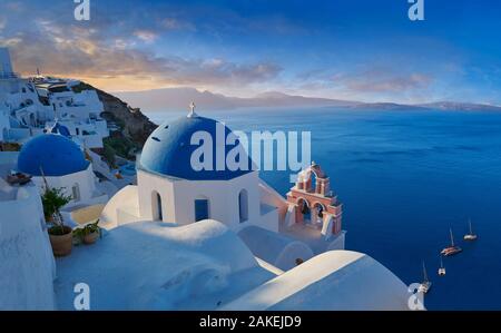 Sunset over the traditional Greek Orthodox churches of Oia (ia), Cyclades Island of  Thira, Santorini, Greece.  The settlement of Oia had been mention Stock Photo