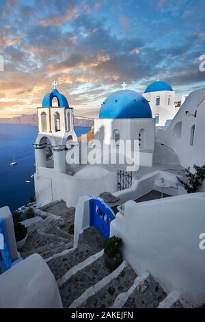 Sunset over the traditional Greek Orthodox churches of Oia (ia), Cyclades Island of  Thira, Santorini, Greece.  The settlement of Oia had been mention Stock Photo