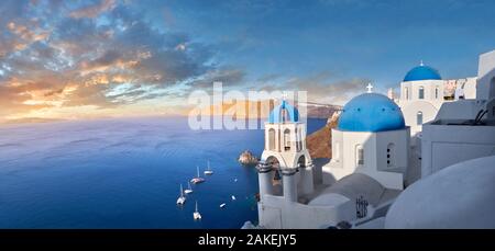 Panoramic sunset over the traditional Greek Orthodox churches of Oia (ia), Cyclades Island of  Thira, Santorini, Greece.  The settlement of Oia had be Stock Photo