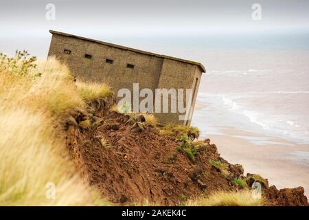 Second World War lookout post leaning over eroding cliff near Aldbrough, Yorkshire, England, UK. August 2013. Stock Photo