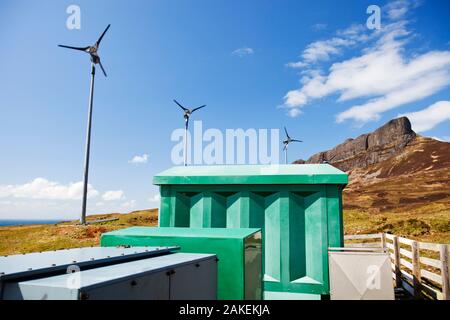 Four wind turbines beneath An Sgurr, Isle of Eigg. Isle of Eigg produces all the energy the island nees from renewable energy. Eigg, Scotland, UK, May. Stock Photo