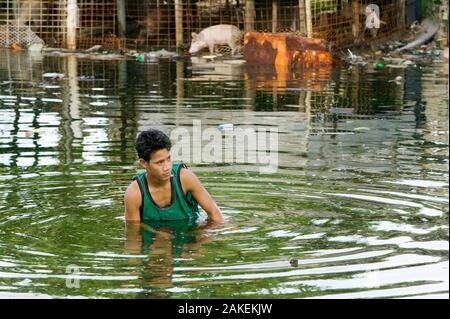 Man in water as Funafuti Atoll is flooded by sea water, Tuvalu. These low lying islands are very susceptible to sea level rise, March 2007 Stock Photo