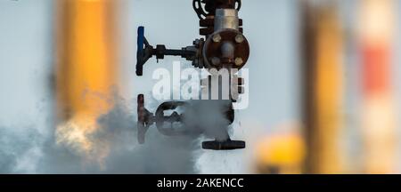 broken valve at the factory hydraulic system, leaking hot liquid and steam under enormous pressure Stock Photo