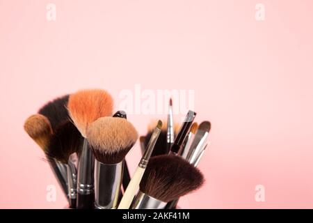 Set of makeup brushes of different sizes on pink background Stock Photo