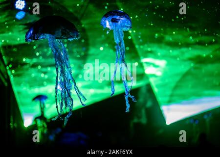 Blue decorative crafted jellyfish as decoration for a street festival with tunnel light from a green laser Stock Photo