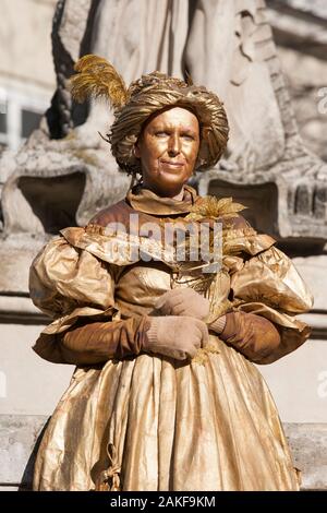 A Woman dressed in period costume and painted in gold works the streets of Lviv Ukraine to make a living as a street artist Stock Photo