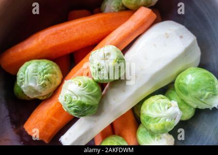 Peeled vegetables carrots, sprouts and parsnip in a pan ready to cook. Stock Photo