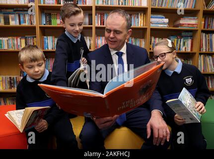 Minister for education Joe McHugh with pupils of St. Malachy's National School in Finglas (from left) Timur Sevcenko (8), Kian Franzoni (9) and Ella Groves (9), for the announcement of a million-euro pilot project in which around 100 schools are to receive free books. Stock Photo