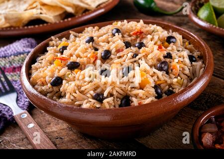 A bowl of delicious black beans and rice on a rustic table top. Stock Photo