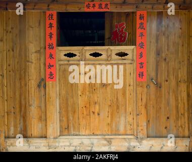 The old traditional style wood carving door with Spring festival couplets during Chinese new year. Stock Photo