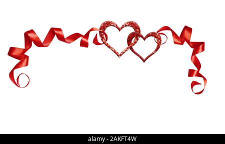 Frame with red silk twisted ribbons and two glitter hearts isolated on white background. Decoration for Valentine’s Day. Stock Photo