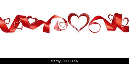 Red silk twisted ribbon and glitter hearts isolated on white background. Decoration for Valentine’s Day. Stock Photo