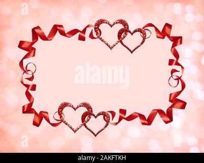 Frame with red silk twisted ribbons and glitter hearts on holiday bokeh background for Valentine’s Day. Stock Photo