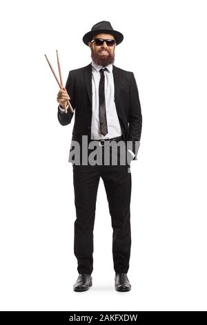 Full length portrait of a male musician in a black suit holding a pair of drumsticks isolated on white background Stock Photo