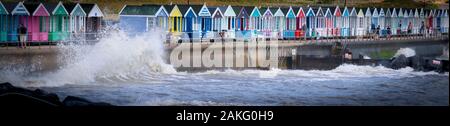 beach hut holidays being splashed by the sea Stock Photo