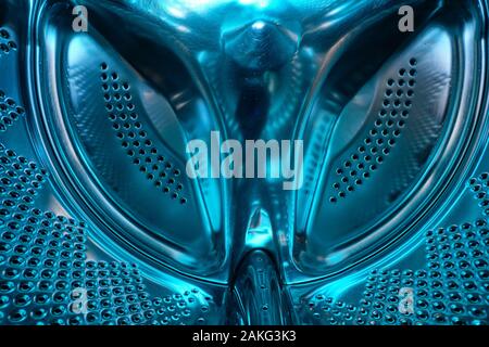 Futuristic look of a washing machine drum made of steel in blue light Stock Photo