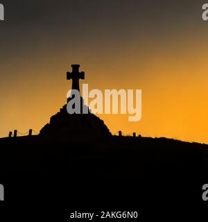 The Newquay War Memorial seen in silhouette at sunset in Newquay in Cornwall. Stock Photo