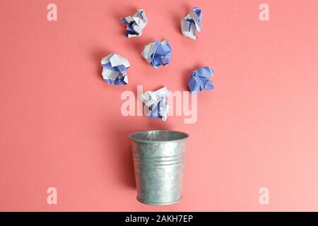 Trash can with trash on pink background Stock Photo