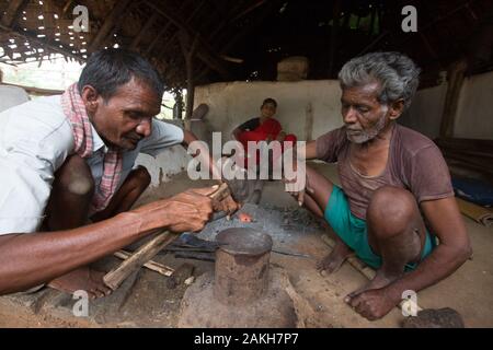 CAPTION: Rajashetty, who contracted polio early in life, is a self-employed blacksmith. He is pictured here working alongside two of his family member Stock Photo
