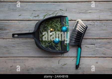 Cleaning up after christmas. Sweeping up pine needles and broken decorations Stock Photo