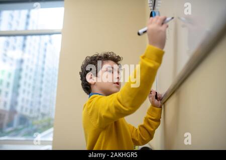 Pupil thinking what to write on the white board Stock Photo