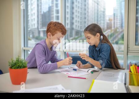 Two classmates working on their writing task Stock Photo