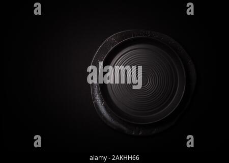Closeup 2 empty round black aged ceramic plates on dark background with copy space. Concept modern shoot menu, restaurant advert, tableware catalog, t Stock Photo