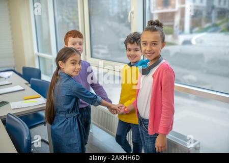 Happy school children preparing to work in team Stock Photo