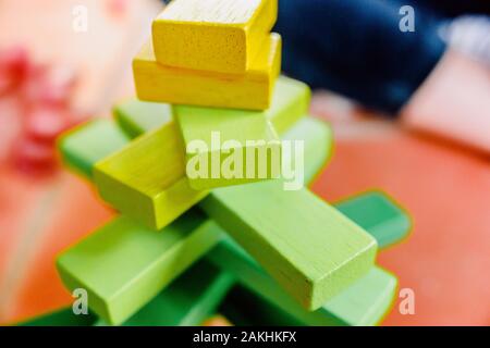 Yellow wooden blocks in balance in a toy tower. Stock Photo