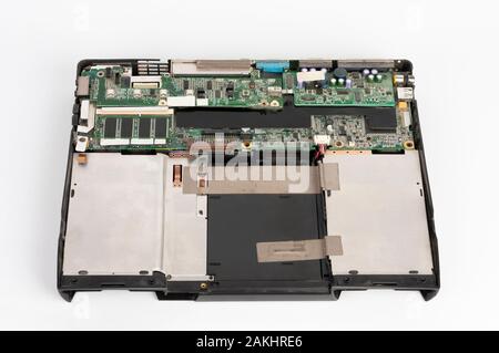 old laptop, removed monitor , keyboard, touchpad, battery, upper cover  and  floppy disk drive on white background Stock Photo
