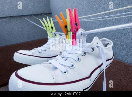 White training shoes, trainers on washing line Stock Photo