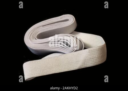 Blanching rubber-band fabric tape for needlework of the cloth insulated on black background Stock Photo