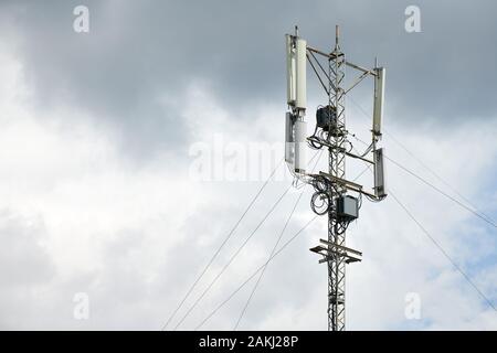 Communication cellular signal tower. 3G, 4G, 5G phone signal base station. Urban antenna repeater tower. Storm warning. Stock Photo