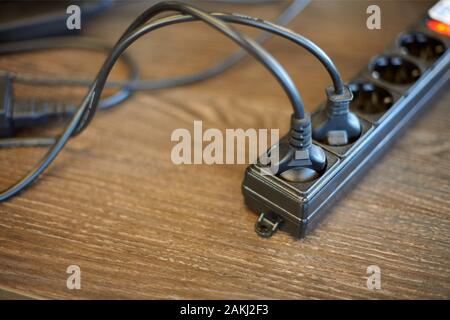 Two plugs plugged into electric power bar. Power supply for computer and monitor. Electrical outlet in which many devices are included Stock Photo