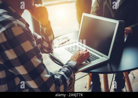 Business man works with laptop on a table in a modern office near window Stock Photo