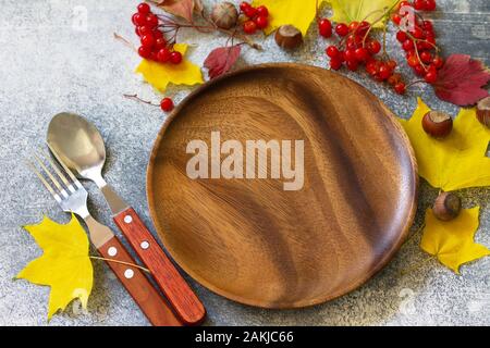 Autumn table setting. Thanksgiving or autumn harvest table setting with silverware and frame of leaves. Stock Photo