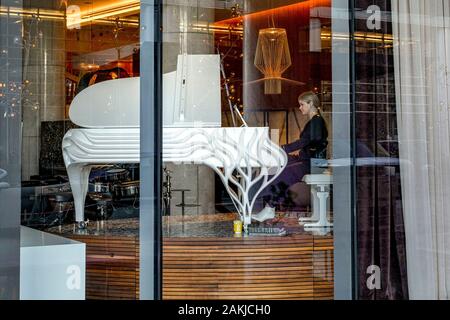 Woman playing ornate grand piano, Fairmont Pacific Rim Hotel, Vancouver, British Columbia, Canada Stock Photo