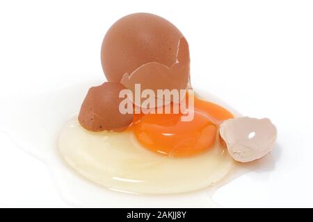 A raw egg cracked on a white surface Stock Photo