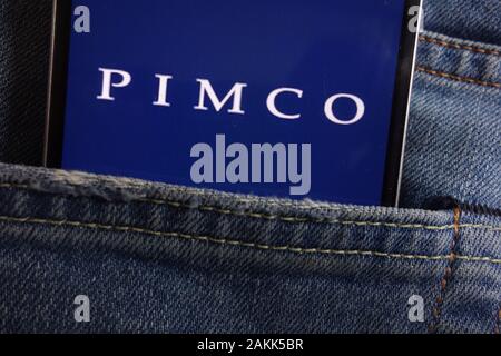 Pimco logo displayed on smartphone hidden in jeans pocket Stock Photo