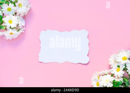 Birthday or wedding mockup with white Chrysanthemums flowers and white empty paper list on pastel pink background Stock Photo