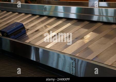 Last suitcase on the baggage claim carousel at the airport Stock Photo