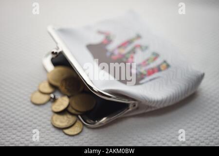 Open purse with golden coins inside and on the table. Wallet for change Stock Photo
