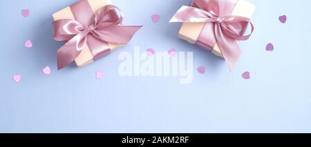Valentines Day background with gift boxes decorated pink ribbon bow and heart shaped confetti. Valentines day, love, romance concept Stock Photo