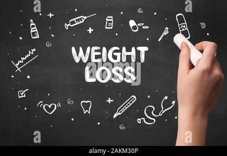 Hand drawing WEIGHT LOSS inscription with white chalk on blackboard, medical concept Stock Photo