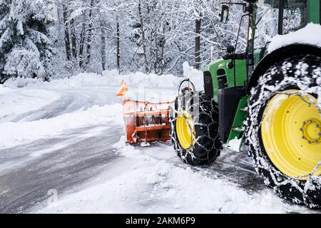 Tractor Cleaning Road From Snow After Heavy Snowfall Stock Photo