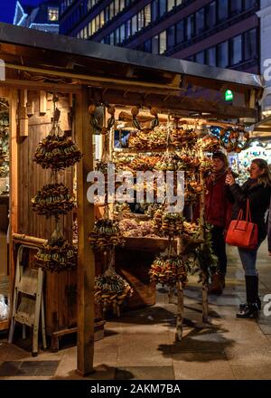 Two women look at a stall selling handmade crafts at the Christmas and Advent Market at Vorosmarty Square in Budapest, Hungary Stock Photo