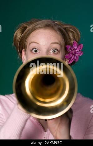 Teen girl cross side while blowing a trumpet Stock Photo